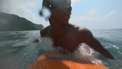 Asian surfer getting barreled on the surf. Blue ocean and scenic landscape at background. Powerful ocean and one man alone do workout with surf barreled at big waves. POV by gopro Arkistovideo