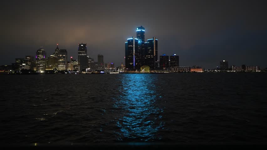 Detroit, MI, USA - June 26, 2023: Skyline of Downtown Detroit, Michigan at night on a rainy day taken from across the Detroit river in Windsor, Ontario 