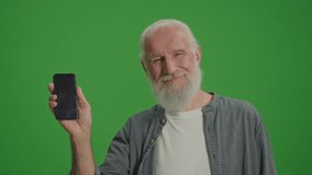 Green Screen. Portrait of a Smiling Old Man with a Smartphone. Emerging Technologies for Seniors.Smart Homes and the Internet of Things for Seniors.