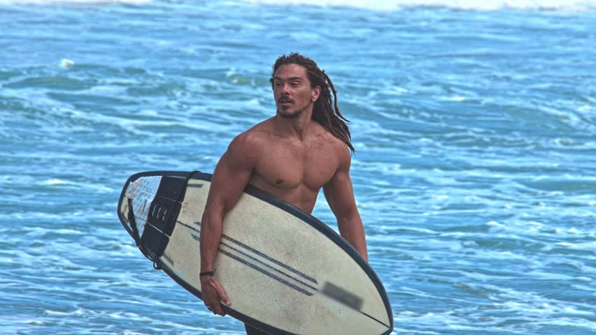 Man Surfer With Surf Board At Sea Nature And Ocean Water Waves On Background. Person At Coast Beach With Surfboard Going Away. Portrait Guy At Seaside Bay Moves To Swimming or Surfing For Relaxation