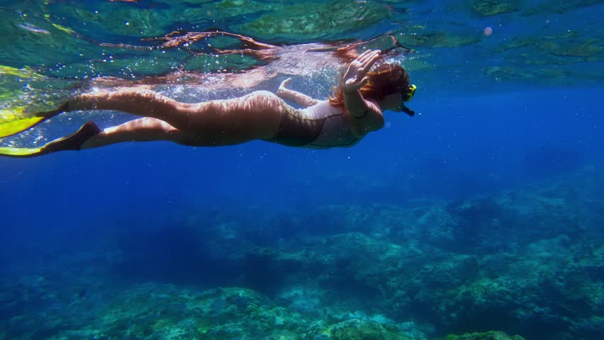 Woman Snorkeling Swimming in Blue Sea Underwater. Freedive in Ocean Water with Girl. Snorkeling and Diving in Deep Sea. Marine Life in Shallow Water. Person Swimming Near Coral Reef in Slow Motion 4k