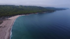 Sandy beach of a summer resort with a blue and clear sea, no people, footage taken from the air on a quadcopter