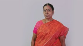 This video is about A south Indian woman saying vanakkam in front of camera on plain background