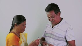 This video is about A south indian wife counting money and husband giving money on plain background