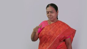 This video is about A south Indian women showing headache on front of camera on plain background