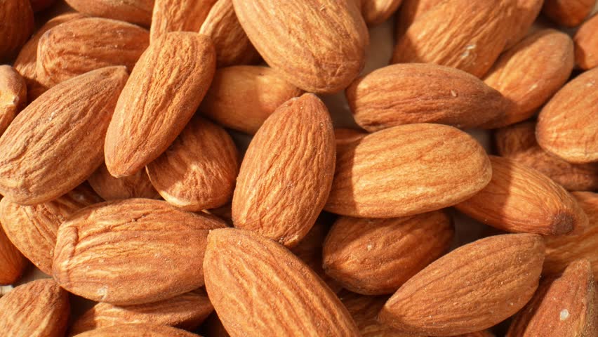 Exquisite macro view of almond kernels: Unveiling their flawless curves, delicate ridges, and lustrous golden complexion, offering a captivating glimpse into their natural allure. Almond background.
