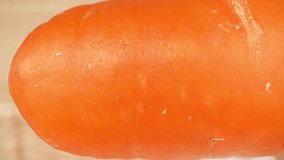 Macro video captures the intricate beauty of a carrot with a probe lens. Explore its vibrant orange hue, delicate textures, and intricate details up close. Carrot background. 4K HDR
