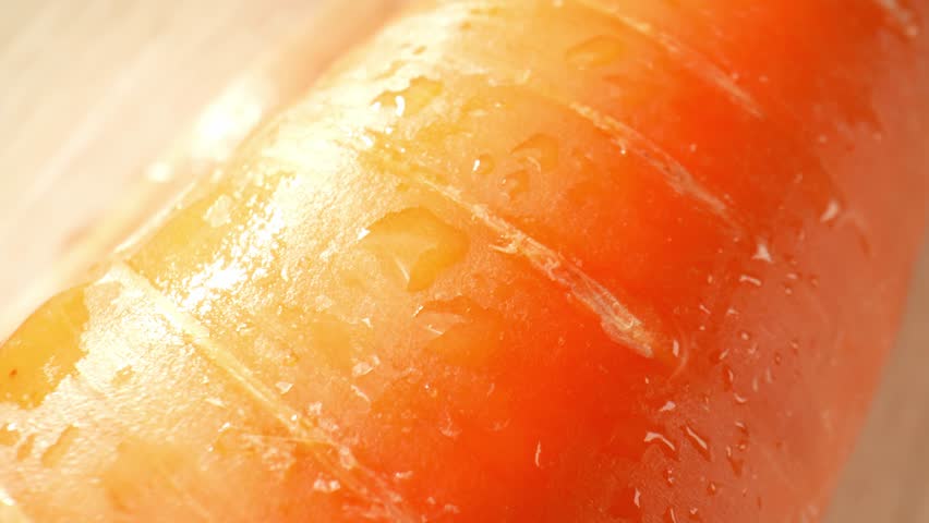 A mesmerizing macro video captures a single carrot with glistening droplets of water. The probe lens reveals intricate textures and details, highlighting the carrot's organic beauty in stunning clarit Royalty-Free Stock Footage #1105686715