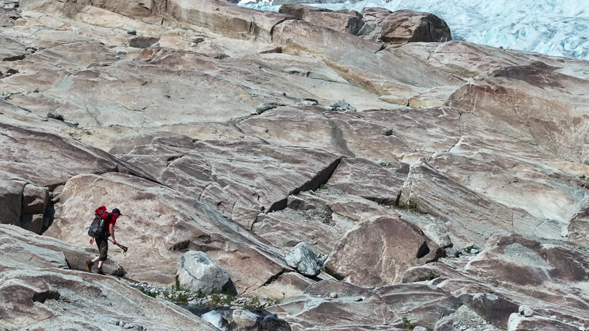 Caucasian Hiker on the Norwegian Kjenndal Glacier Trail Aerial Vista