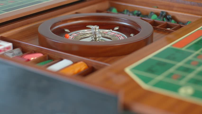 Casino roulette wheel with chips, dice and cards close up