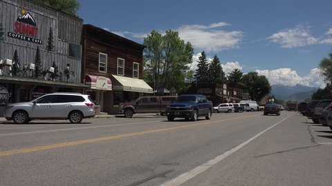 ENNIS, MONTANA - JUN 2015: Rural Ennis Montana main street business traffic 4K. Ennis is the center of a long historical ranching economy in the Madison River valley near Yellowstone National Park.
