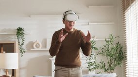 Vr Virtual reality Explore Experience Asian adult male Exiting surprise after wear vr goggle headset and join future technology virtual augmented new world while relax casual in living room at home - Powered by Shutterstock - Get 15% off with code: PIKWIZARD15