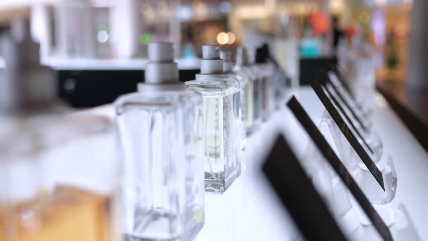 Close up of perfume in showcase, hand of woman buyer takes perfume bottle to inhale fragrance before buying, slow motion. Concept of cosmetics store, perfume shopping Royalty-Free Stock Footage #1105696843