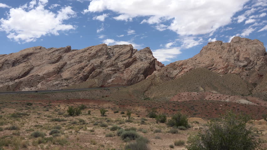 GREEN RIVER, UTAH - JUL 2015: San Rafael Swell Utah traffic scenic desert landscape 4K. Large geologic feature. Sedimentary rocks into numerous valleys, canyons, gorges, mesas and buttes. Managed BLM.