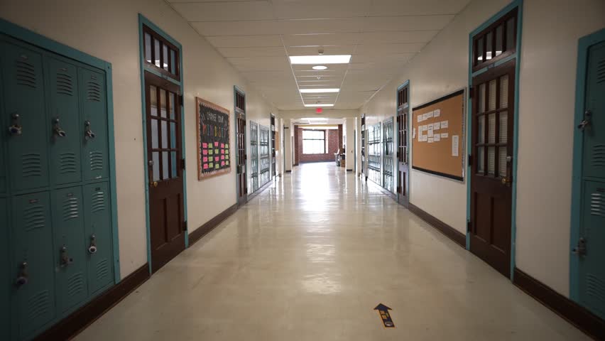 Wide angle push in down a long empty high school corridor hallway lined with student lockers. Royalty-Free Stock Footage #1105701025