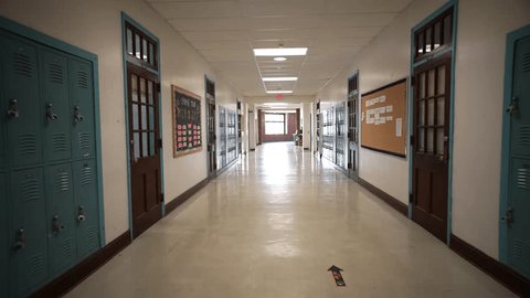 Wide angle push in down a long empty high school corridor hallway lined with student lockers., videoclip de stoc