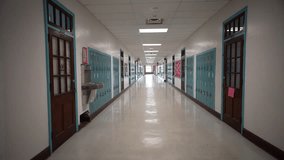 Wide angle push in down a long empty high school hallway with US American flag with corridor lined with student lockers. - Powered by Shutterstock - Get 15% off with code: PIKWIZARD15