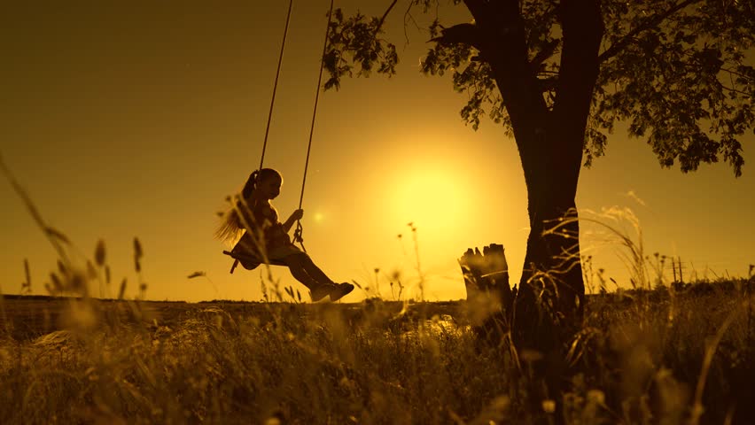 Silhouette, Baby swing, kid girl smile in flight. Child plays on wooden swing, dreams of flying. Holiday family happiness, dreams. Happy little girl swings on swing in park under tree, sunset. Kid sun
