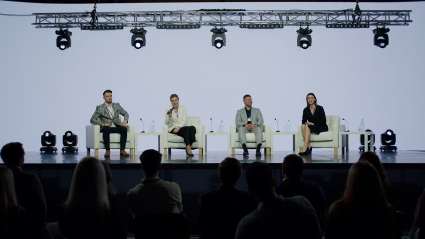 Group of 4 experts sitting on stage, answering audience questions during the conference. Neutral white bacgkround Royalty-Free Stock Footage #1105704381