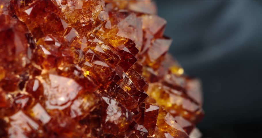 citrine (heated amethyst) rotating in 4k. macro detail texture background. close-up raw rough unpolished semi-precious gemstone