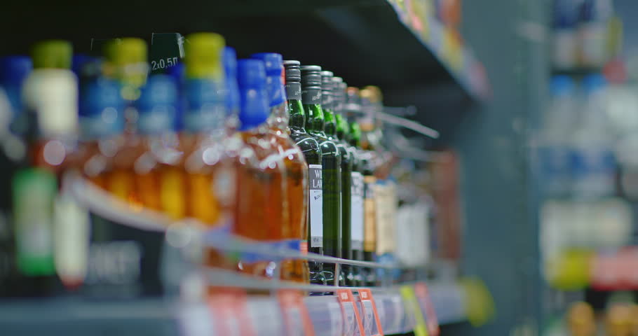 alcohol addicted man taking whisky bottle from shelf in liquor store, closeup of hand, 4K, Prores Royalty-Free Stock Footage #1105712273