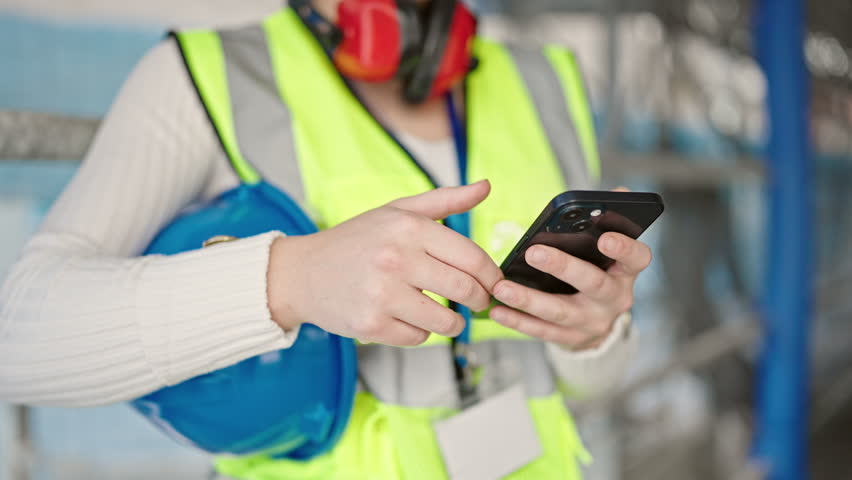 Young blonde woman architect using smartphone with winner expression at street