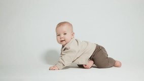 portrait of a child who learned to crawl, video on a light studio background