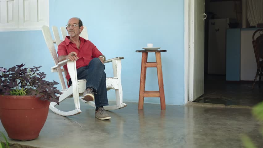 Senior Hispanic Man relaxing at home - Retired person resting at his porch