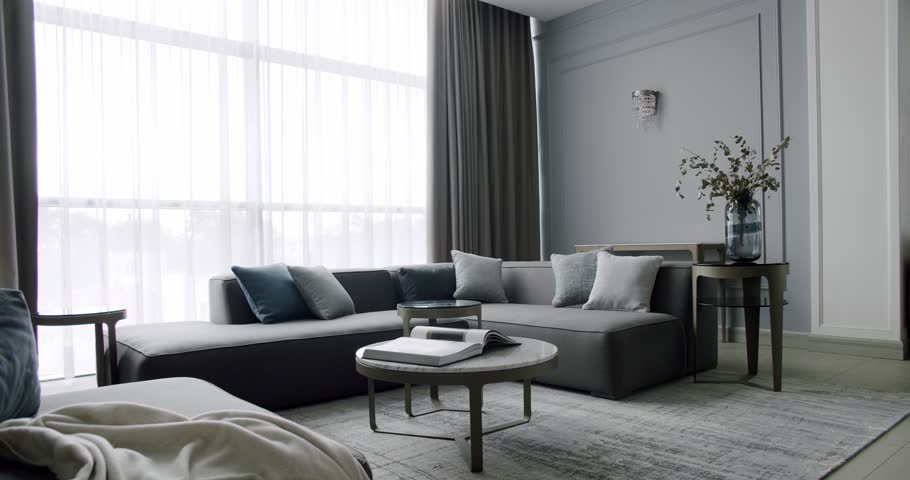 Modern contemporary living room with gray furniture. Modern House Interior With Corner Sofa round table. Fashionable furniture. Minimalist Home Interior. Cozy Modern Furniture. Luxury Elegant Room
