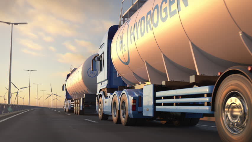 Convoy of generic electric semi trucks with hydrogen tank trailer driving along a bridge or coastal highway with wind turbines in background. Renewable energies concept. Realistic 3d animation.