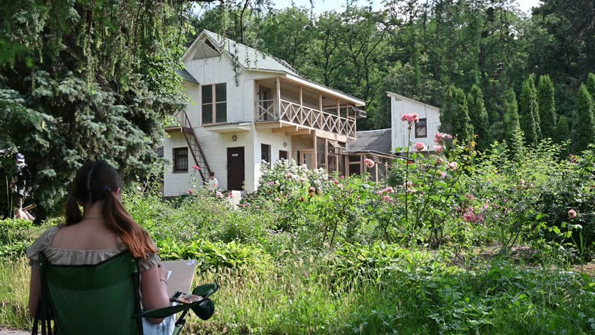 girl draws roses on the background of the dovecote