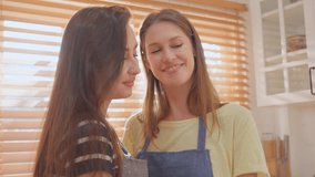 Caucasian young lesbian couple spend time together in kitchen at home. Attractive romantic LGBTQ girl friend feeling happy and relax, looking  at each other with happiness. Homosexual-LGBTQ concept. - Powered by Shutterstock - Get 15% off with code: PIKWIZARD15