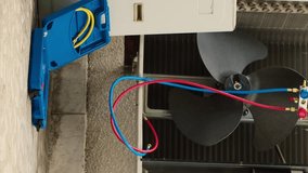 Vertical video Faulty condenser with protection cover removed in need of mending, with defective electric internal parts. External air conditioner not functioning anymore, ready to be repaired, zoom - Powered by Shutterstock - Get 15% off with code: PIKWIZARD15