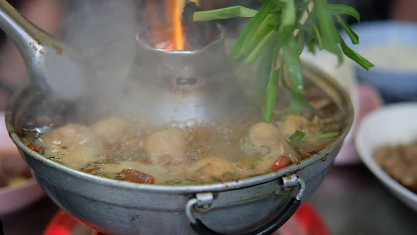 Slow motion of Braised beef clear with meat tendon soup stew with vegetable in a hot pot. Close up on coals are burning and soup boiling Royalty-Free Stock Footage #1105731019