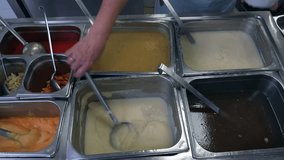 Video of pots and pans in a large canteen restaurant kitchen filled with food ready to put on plates