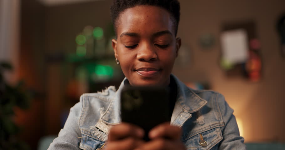 Social media manager influencerAfrican woman in living room engages in chat messaging conversation responding to comments collaborating with brands and fellow content creators. Royalty-Free Stock Footage #1105741445