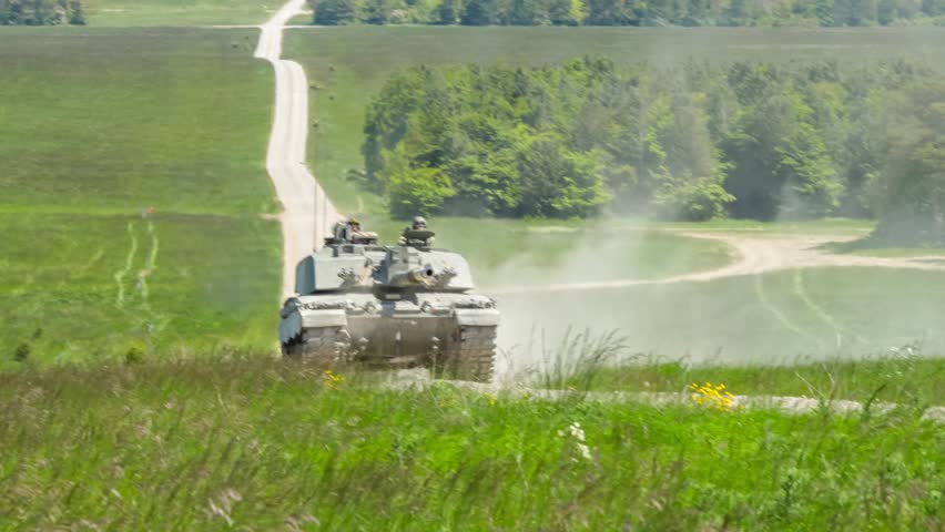 close-up of a commander and gunner directing a british army Challenger 2 ii FV4034 main battle tank in action on a military battle exercise, Wiltshire UK   