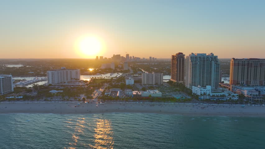 Fort Lauderdale city with high luxury hotels and condos. Aerial view of Las Olas Beach sandy surface with tourists relaxing at warm Florida suntet. Tourism infrastructure in southern USA Royalty-Free Stock Footage #1105744765