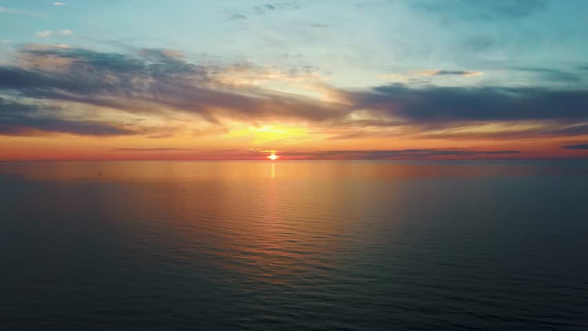 Aerial View of the Baltic Sea at Sunset, Pavilosta, Latvia. Beautiful Golden Sunset Over the Beach Seascape. Glittering Sunlight Reflection. The Baltic Sea at the Mouth of Saka River in Courland
