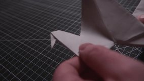 Folding a paper origami flying swan close up macro shot - Powered by Shutterstock - Get 15% off with code: PIKWIZARD15