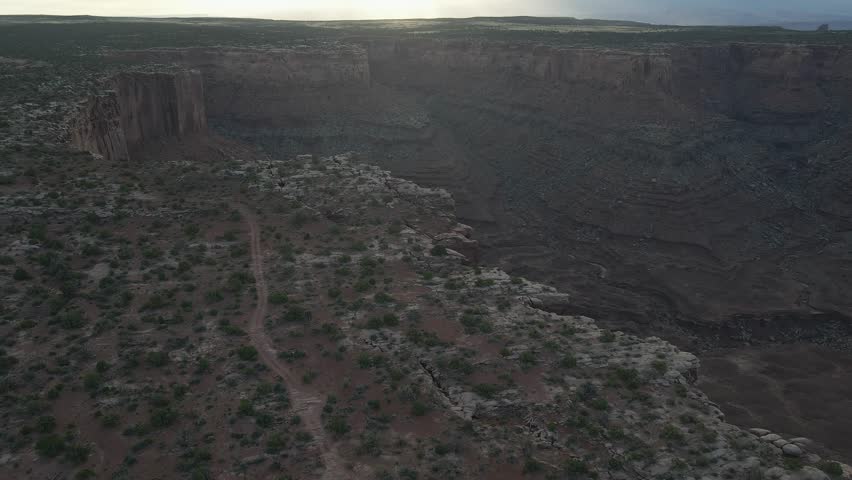 Trail in desolate canyon landscape, sweeping aerial. Marlboro Point, Utah