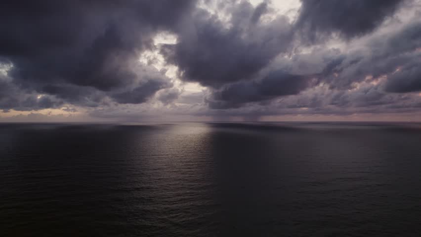Aerial view dark cloudy over sea, Drone view of peaceful calm dark black sea water surface, cloudy sunset or sunrise sky,Storm clouds dark sky gloomy rain clouds over a calm sea background
