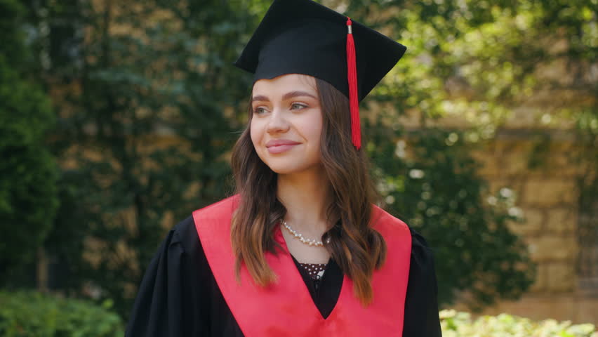 Students celebrate graduation. Portrait of young woman dressed in gown mantle and graduation cap. Royalty-Free Stock Footage #1105760085