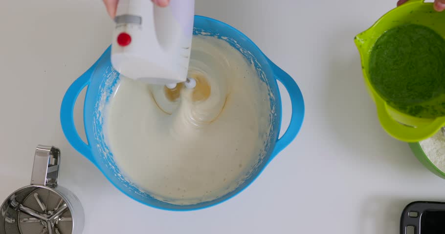 Woman putting spinach into dough for healthy bakery