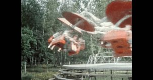 Close up, people enjoying fun on attraction in amusement entertainment park. People ride chairoplane carousel. Funfair leisure. Archival vintage color film. Archive lifestyle Retro 1980s Moscow Russia