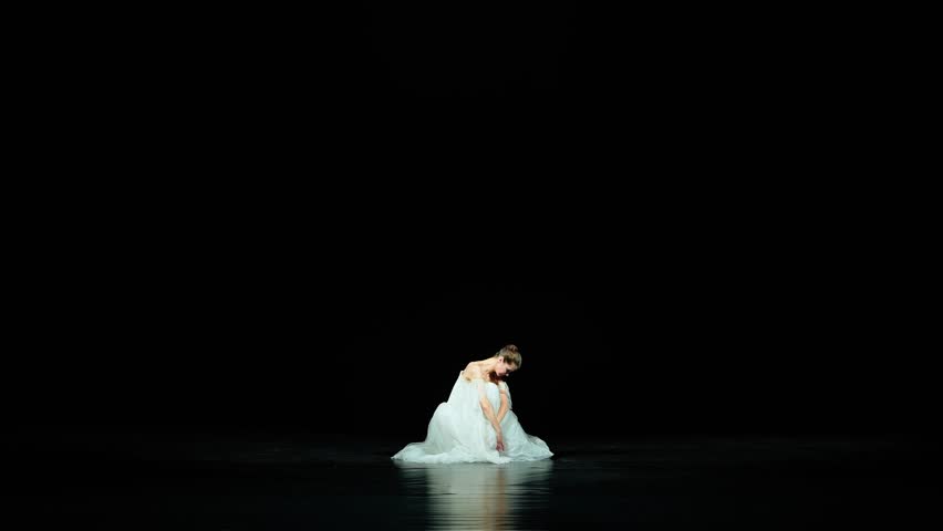 Ballet, elegant ballerina in a white tutu dance and perform choreographic elements on a black background, beautiful dramatic dance. Royalty-Free Stock Footage #1105768337