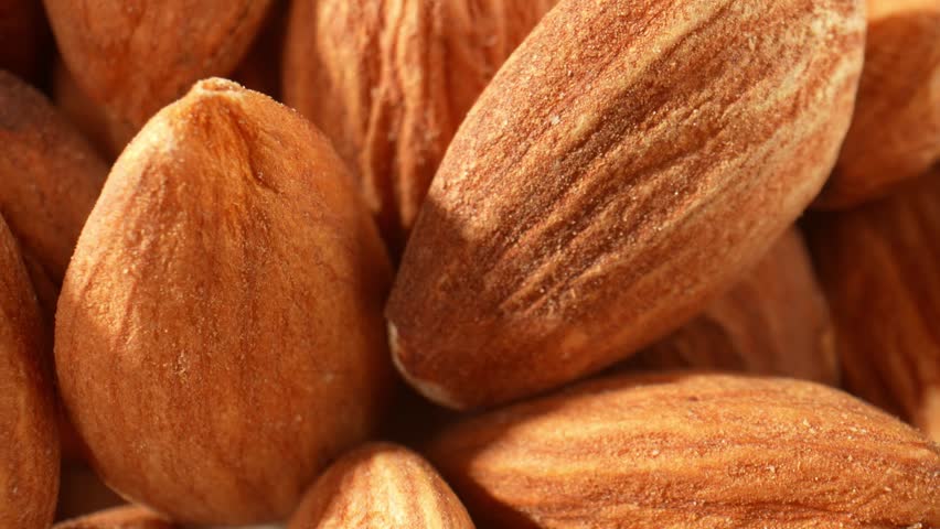 In a macro video of almond kernels, the intricate details and textures of the almonds are captured in stunning close-up shots. Food and snack concepts. Almond kernels background. 4K HDR
