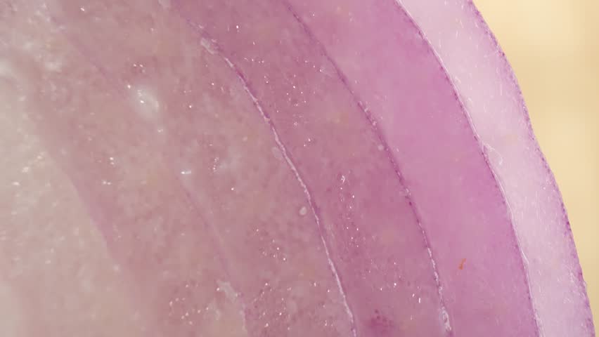 Vibrant and captivating, red onions shine under a macro lens. Explore their intricate layers and rich hues in a mesmerizing video, showcasing their beauty up close. Red onions background. 4K UHD
