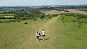 Drone Shot Of Mature Couple Walking With Pet Dog Through Beautiful English Countryside In Oxfordshire England UK - Powered by Shutterstock - Get 15% off with code: PIKWIZARD15