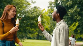 Young couple travelling through city park eating ice cream together which woman accidentally drops - shot in slow motion - Powered by Shutterstock - Get 15% off with code: PIKWIZARD15